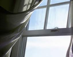 open window with gentle breeze blowing through wispy sheer curtain